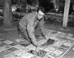 W. F. Hoeflein laying part of the fireplace floor at his home