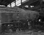 Texas and Pacific Railroad; workers with old locomotive inside roundhouse