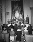 Saint Patrick's Catholic Church. Group of people praying in front of altar by Tom Dillard