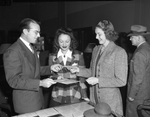 Mr. W. H. Larsen, selling $150 worth of bonds to Miss Mona Harris (center) and Miss Nancy Tomlinson.