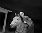 Elmer Vaught mounting his roping pony, "Stardust"