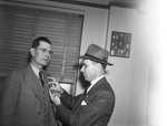 Detective Theron Brooks (right) pinning a badge on Howard Grant, new chief detective