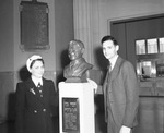 Mr. and Mrs. J. E. Lipe stand beside bust of Will Rogers