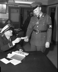 Lieutenant C. T. Stamp handing Policemen's Ball tickets to N. O. Shepherd