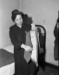 Mrs. Sarah Jane Williams of the Salvation Army shows the tattered vest pocket of the late John W. Snow
