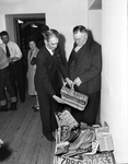 W. A. Rodgers (right) giving old automobile license plates to Tax Assessor-Collector John Bourland