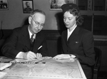 Postmaster Young selling defense stamp to stewardess Irene Kellman