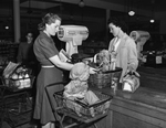 Miss Frankie Gholson (right) checking groceries for Mrs. John Hancock