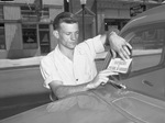 Mark A. Hovenkamp, pasting a "The Avengers of Pearl Harbor" sticker on a car's windshield