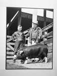 Claude Spurlock, Swift and Company hog buyer, shown with young Louise Armstrong looking at a hog
