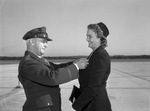 First Lieutenant E. E. McElroy.Major General Barton K. Yount pins the Distinguished Flying Cross on Mrs. E. E. McElroy for her husband