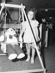 Toys. Linda Scott looking at stuffed Panda and wooden doll swing