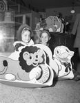 Toys. Twins Frances and Clifton Ferguson riding in "Shoo-flies" made of fiberboard