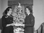 Mrs. Mary Helen Brown, left, handing Christmas present to Corporal Sara Langley of the Marines