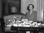 Mrs. Thomas F. West shown with presents to be distributed by Red Cross