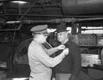 Colonel Wannie L. Bartley, commanding officer of Fort Worth Quartermaster Depot, pins a distinctive service ribbon on Burnett D. Hill, 67