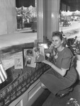 Mrs. Margaret Thomason arranging window display for Fourth War Loan Drive