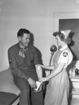 Blood Donor Service. Mrs. R. C. Barthold, Nurses Aide, applies a bandage to the arm of Staff Sergeant Michael J. Barry