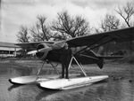 Captain Robert S. Fogg, standing on a pontoon. A Fairchild seaplane is shown on Lake Worth