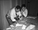 William H. Price, recreation leader at the Arlington Community Center, showing a fine point in wood craft to Wyman Higdon