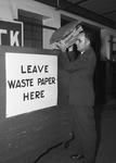 Waste Paper Collection: P. C. Farris tossing waste paper into the the collection bin