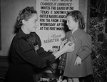 Evelyn Ann Center, 3, receives a badge from Miss Laverne Nance