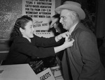Mamie Snodgrass of the Fort Worth Chamber of Commerce pinning badge on J. O. Selman