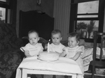 Ferguson triplets, left to right, Tina Ruth, William Ray and Nina Sue looking at their birthday cake