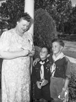 Mrs. H. V. Cardona signs card pledging volunteer work at surgical dressings room as Cub Scouts look on