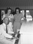 Peninsula Club opening. J. J. Hurley, president of club, plays piano for Mrs. Grover Cline Junior, left, and Miss Geneva Allen