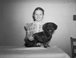 Southwestern Dachshund Club. Show. Norma Shulz, daughter of Mr. and Mrs. R. Shulz, with her black dachshund puppy, "Cecelia"