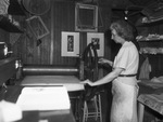 Miss Blanche McVeigh operates the press with which she makes her prints and aquatints