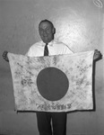 J. W. Wheeler shown holding Japanese flag.