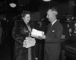 Mrs. Glenn Rothelle, secretary at Fort Worth-Tarrant County Tuberculosis Society, delivers first tuberculosis Christmas Seal letters to Fort Worth Postmaster H.D. Young, 11/27/1944