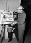 Salvation Army Christmas kettle O. L. Blanton, Civitan President, pouring donation into kettle, while Major William Johnson of the Salvation Army looks on
