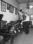 City Detectives Hilts, front, and Hightower checking numbers on stolen typewriters, radios, etc