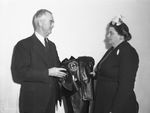 Mrs. C. L. Mansfield, presents rain cape and cap to Assistant School Superintendent Joe Moore