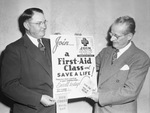 First Aid Drive. Red Cross M. Frank Kinney (left) and Walter Stark (right) show first aid folder