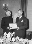 Brigadier Ray Gearing, left, divisional commander of Salvation Army, shown presenting award to Leo Potishman
