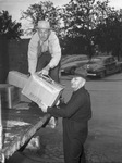 Used Clothes collection. Fred De Malade, left, handing bundle to Arthur Massey