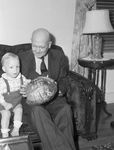 Police Chief with his grandson, Thomas Dale Curry shown with coconut sent to Thomas by Private W. L. Counts