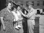 Mrs. Virginia Barnett receiving medal from Colonel W. L. Bartley. She is holding her 2 year old daughter, Michele Lee and Mrs. W. L. Barnett is at the left