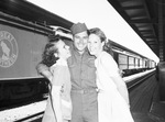 Returing veterans at T & P station: Private First Class John Myrick with his mother and sister