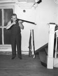 John L. Brooks inspecting a rifle