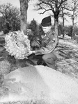 Army Sergeant John S. Reeder Junior, 19 and a tank gunner, places a wreath on his mother's grave