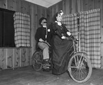 Doctor. C. P. Hines and Mrs. Houston Small on a bicycle built for two at the Fort Worth Dental Society's and Auxiliary's "Floradora Frolic"