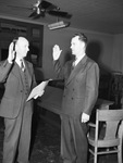 Chief Justice Atwood McDonald left, administrating oath of office to Thomas J. Renfro