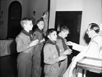 Reverend Thomas J. Taaffe, paster of Holy Name Church, awarding "Ad Altare Dei" cross to Boy Scouts Joseph Holt, Joseph Nasche, Billy Brey and John J. Byrne