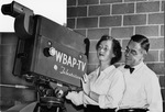 Joe Wilkinson, representing sponsor Humble Oil, inspects WBAP-TV camera on a tour with Pat Cranston