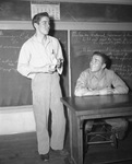 Masonic Home football player Hardy (Gordy) Brown at desk with Leonard Roach talking to class